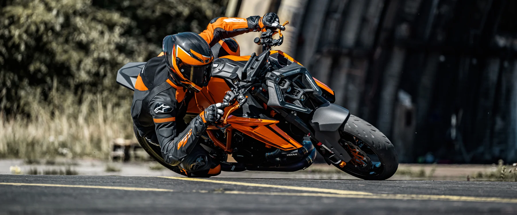 Piloto equipado numa KTM 1390 Super Duke R em curva — fotografia de campanha KTM